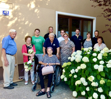 Familienfoto vor einem Haus mit blühenden Hortensien im Vordergrund.