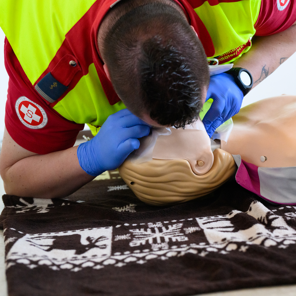 Erste-Hilfe-Trainer in Samariterbund-Uniform demonstriert Mund-zu-Mund-Beatmung