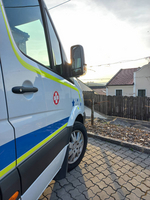 Ein Einsatzfahrzeug parkt vor einem Wohnhaus bei Sonnenuntergang.