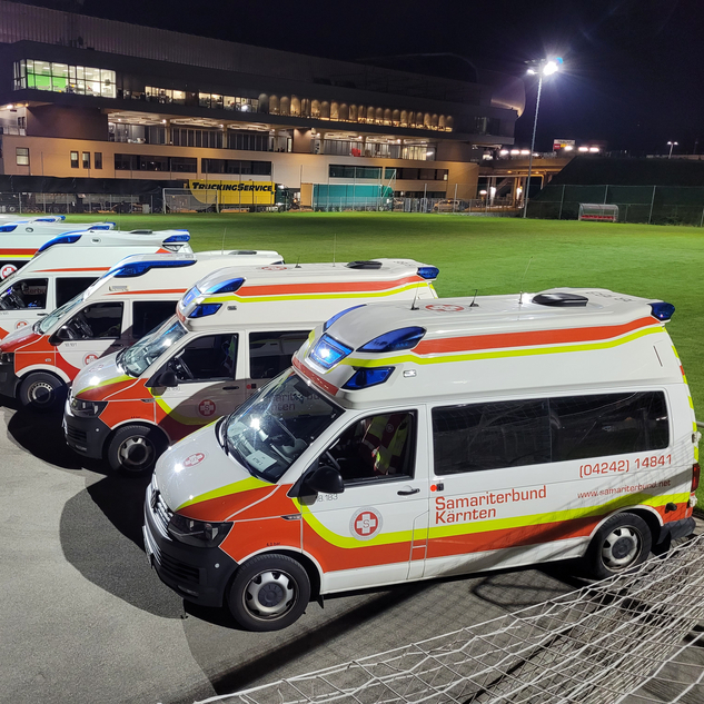 Samariterbund-Fahrzeuge in einem Stadion bei Flutlicht